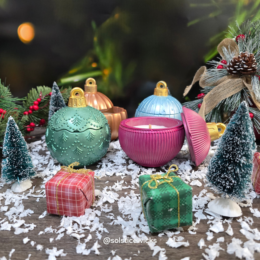 Decorative candles shaped like Christmas ornaments on a festive background with trees and lights.