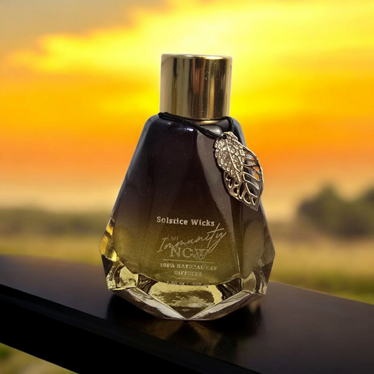 Glass reed diffuser labeled “Sacred Breath” with lemon slices, rosemary sprigs, eucalyptus leaves, and frankincense resin — invigorating, immunity-supporting essential oil blend.