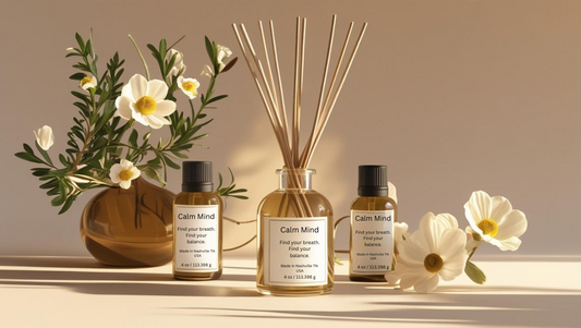 Glass reed diffuser labeled “Calm Mind” surrounded by Roman chamomile flowers, petitgrain leaves, and cedarwood — grounding essential oil blend for relaxation and mental clarity.